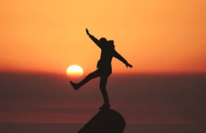 image of person standing with the sunset in the background